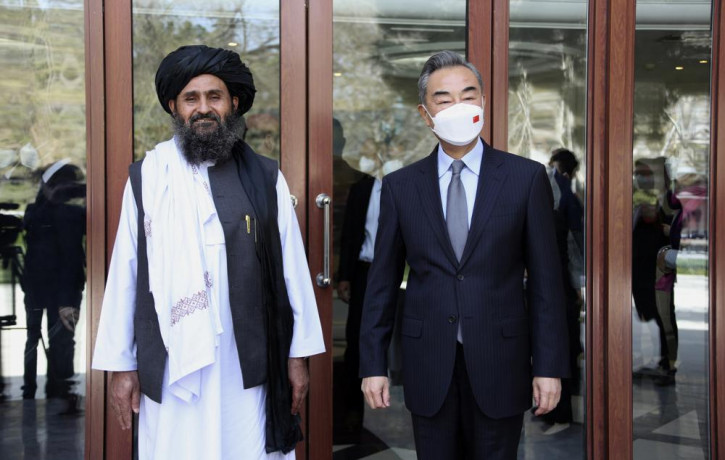 In this photo released by Xinhua News Agency, Chinese Foreign Minister Wang Yi, right, stands next to Mullah Abdul Ghani Baradar, acting deputy prime minister of the Afghan Taliban's caretake