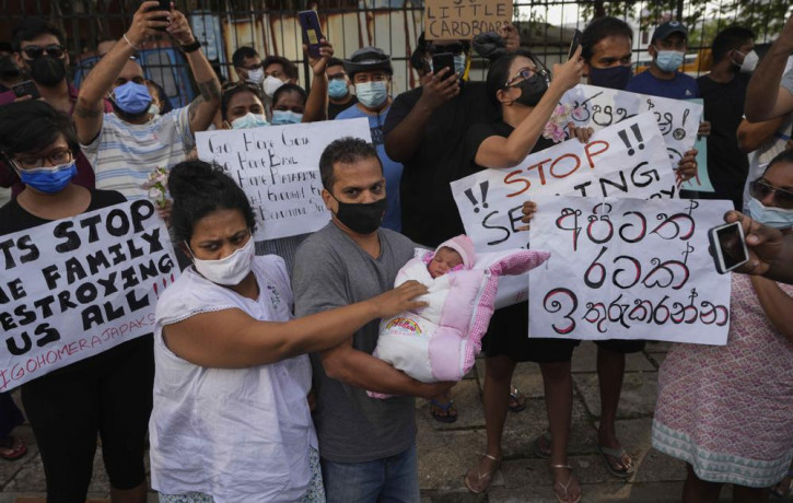 A Sri Lankan couple with their infant join an anti government protest during a curfew in Colombo, Sri Lanka, Sunday, April 3, 2022.