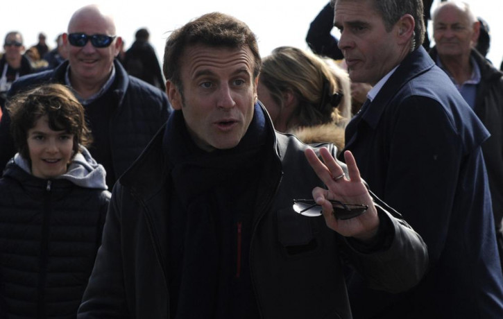 French President and centrist presidential candidate for reelection Emmanuel Macron gestures as he strolls after voting for the first round of the presidential election, Sunday, April 10, 202