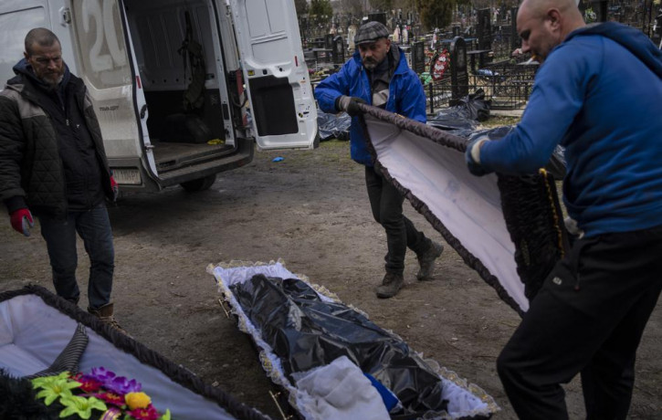 Cemetery workers prepare the coffin for a person killed during the war with Russia in the cemetery in Bucha, in the outskirts of Kyiv, Ukraine, Monday, April 11.