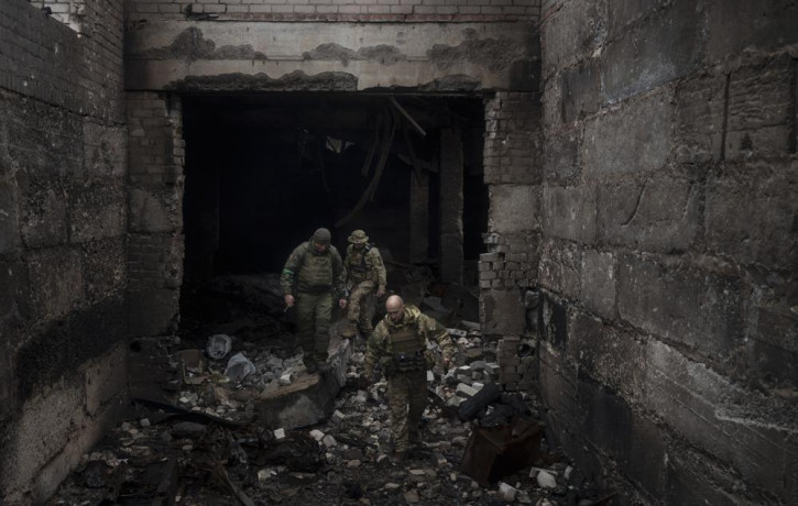 Ukrainian soldiers walk in a building previously used by Russian soldiers as a temporary base in Malaya Rohan, on the outskirts of Kharkiv, Ukraine, Tuesday, April 12, 2022.