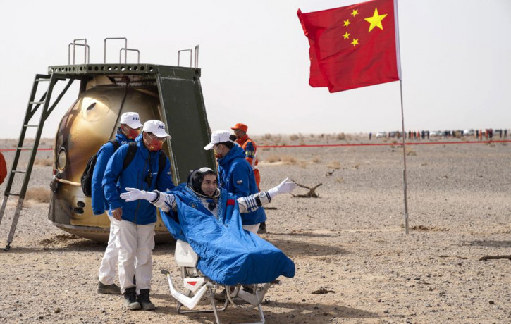 Chinese astronaut Ye Guangfu sits outside return capsule of the Shenzhou-13 manned space mission after landing at the Dongfeng landing site in northern China's Inner Mongolia Autonomous Regio