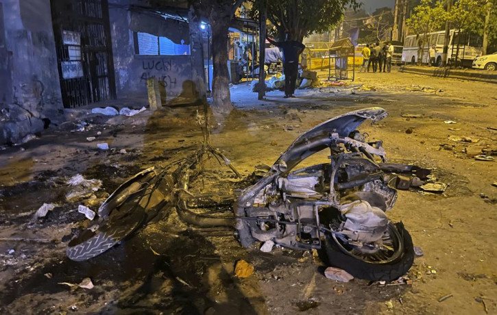 Burnt remains of a motorcycle lie in a street after communal violence in New Delhi, India, Sunday, April 17, 2022.