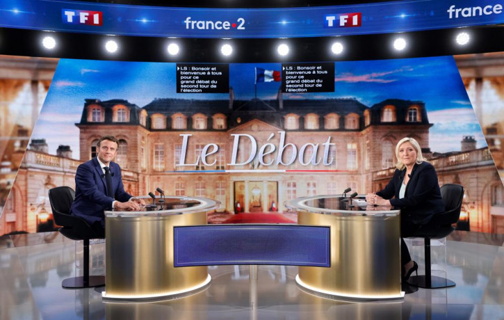 Centrist candidate and French President Emmanuel Macron, left, and far-right contender Marine Le Pen pose before a televised debate in La Plaine-Saint-Denis, outside Paris, Wednesday, April 2