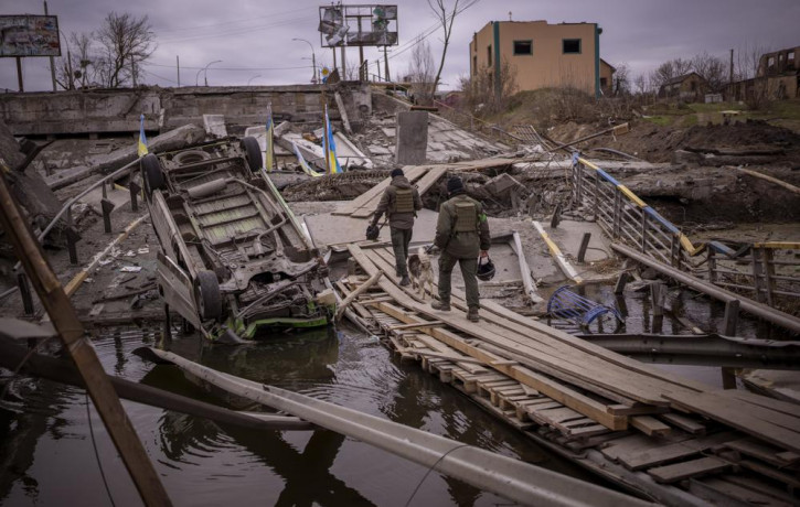 Ukrainian soldiers walk on a destroyed bridge in Irpin, on the outskirts of Kyiv, on Wednesday, April 20, 2022.