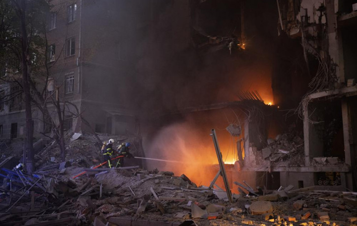 Firefighters try to put out a fire following an explosion in Kyiv, Ukraine on Thursday, April 28, 2022. Russia mounted attacks across a wide area of Ukraine on Thursday, bombarding Kyiv durin