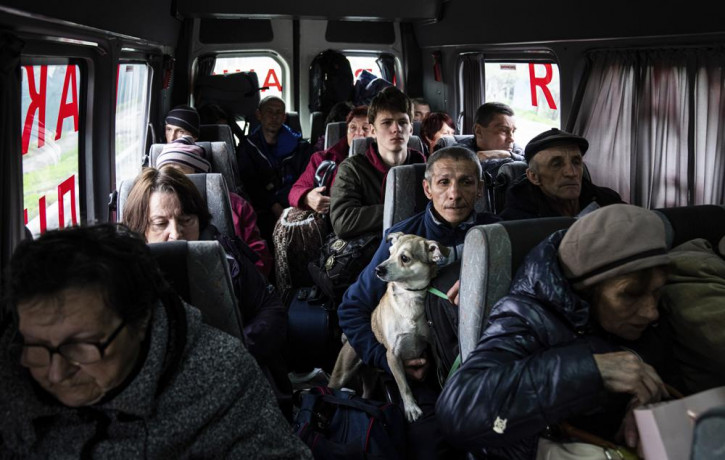 People sit in a bus during evacuation from Lyman, Donetsk region, eastern Ukraine, Saturday, April 30, 2022.