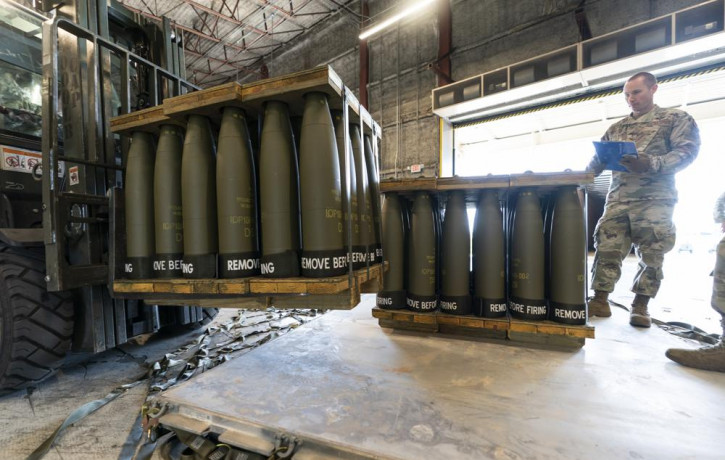 U.S. Air Force Staff Sgt. Cody Brown, right, with the 436th Aerial Port Squadron, checks pallets of 155 mm shells ultimately bound for Ukraine, Friday, April 29, 2022, at Dover Air Force Base
