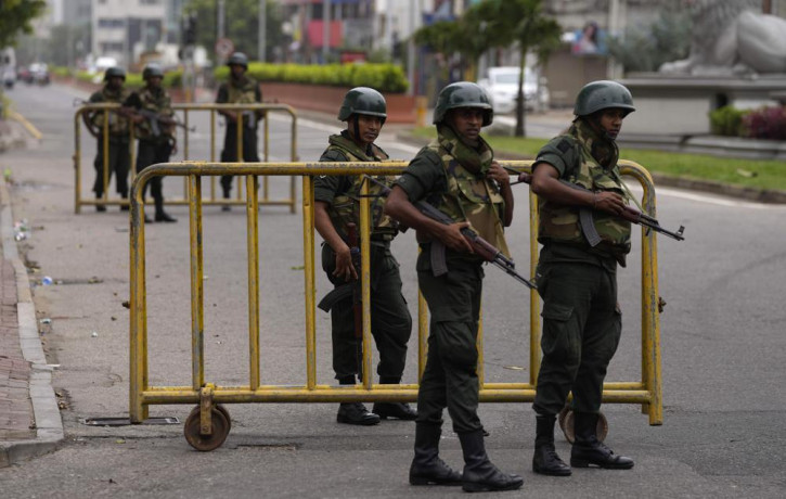 Sri Lankan army soldiers guard a check point outside prime minister's residence a day after clashes between government supporters and anti-government protesters in Colombo, Sri Lanka, Tuesday