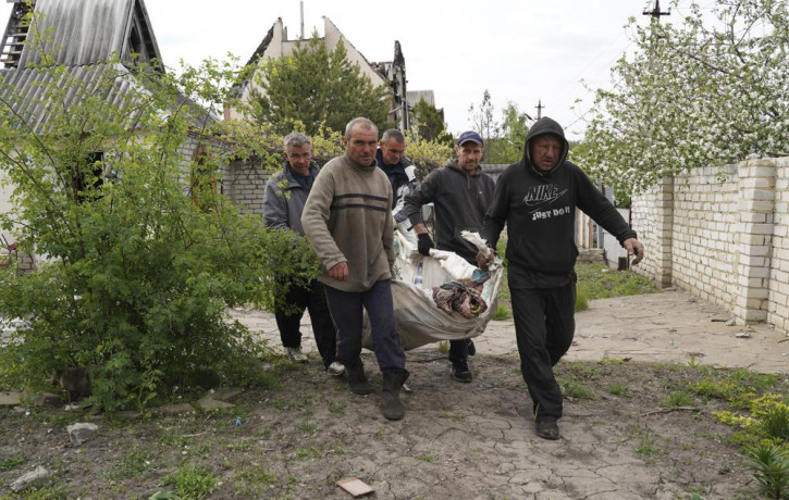 Volunteers exhume the bodies of civilians killed by Russian shelling in the village of Stepaky, close to Kharkiv, Ukraine, Wednesday, May 11, 2022.
