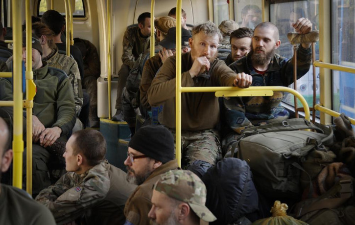 Ukrainian servicemen sit in a bus after they were evacuated from the besieged Mariupol's Azovstal steel plant, near a remand prison in Olyonivka, in territory under the government of the Done