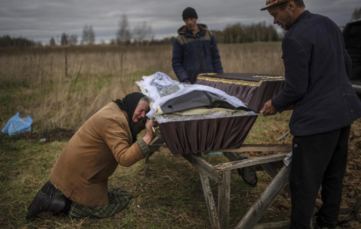 FILE - Nadiya Trubchaninova cries over the coffin of her son, Vadym, who was killed on March 30 by Russian soldiers in Bucha, Ukraine, during his funeral in the cemetery of nearby Mykulychi, 