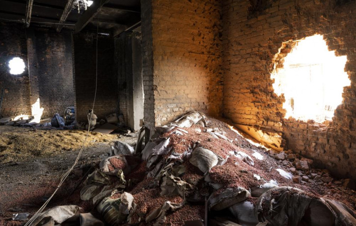 FILE - Scattered grain sits inside a warehouse damaged by Russian attacks in Cherkaska Lozova, outskirts of Kharkiv, eastern Ukraine, May 28, 2022.