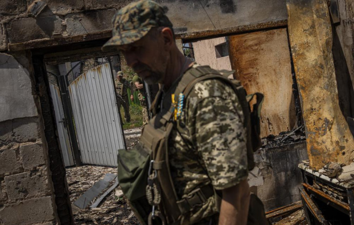FILE - Commander of an artillery unit of the Ukrainian army, Mykhailo Strebizh, center, inside a destroyed house due to shelling in a village near the frontline in the Donetsk oblast region, 