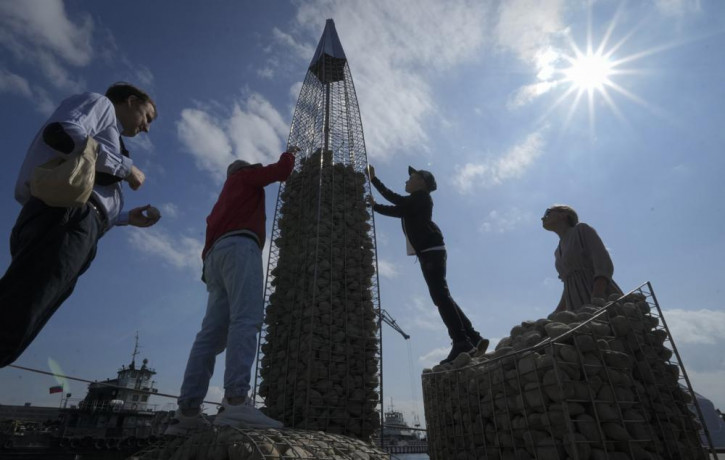 FILE - People build a model of the business tower Lakhta Centre, at the headquarters of Russian gas monopoly Gazprom, filling the frame with stones, in St. Petersburg, Russia, Thursday, June 