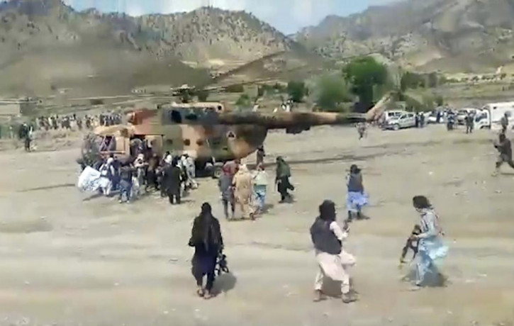 In this image taken from video from Bakhtar State News Agency, Taliban fighters secure a government helicopter to evacuate injured people in Gayan district, Paktika province, Afghanistan, Wed
