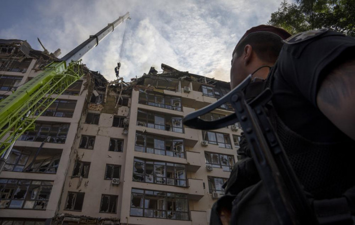 Servicemen work at the scene at a residential building following explosions, in Kyiv, Ukraine, Sunday, June 26, 2022.