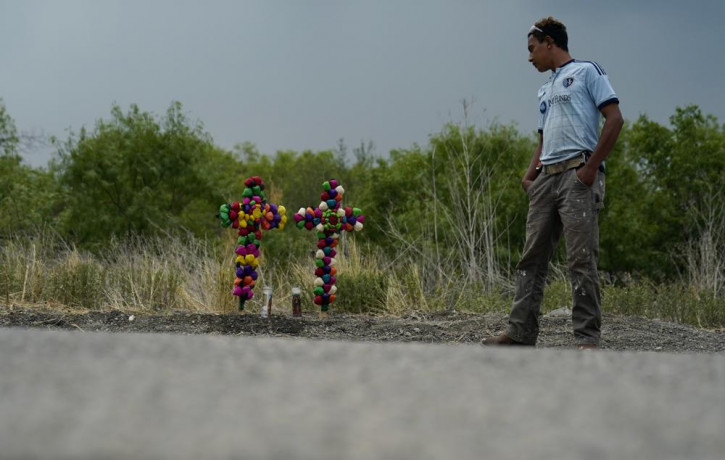 A man pays his respects at the site where officials found dozens of people dead in a semitrailer containing suspected migrants, Tuesday, June 28, 2022, in San Antonio. AP/RSS Photo