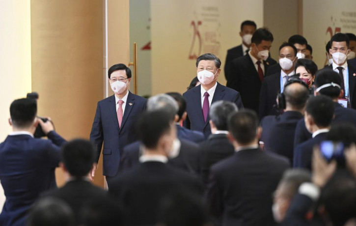 China's President Xi Jinping, center, arrives with Hong Kong's incoming Chief Executive John Lee, facing at left, for Lee's swearing in ceremony in Hong Kong Friday on the 25th anniversary of