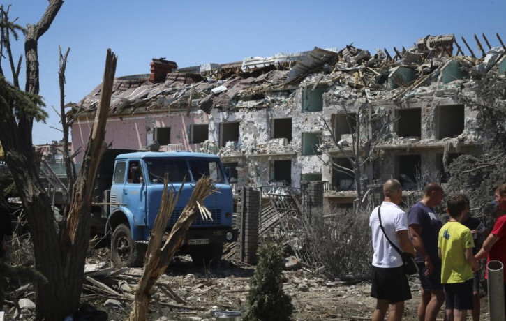 Local residents stand next to damaged residential building in the town of Serhiivka, located about 50 kilometers (31 miles) southwest of Odesa, Ukraine, Friday, July 1, 2022.  AP/RSS Photo