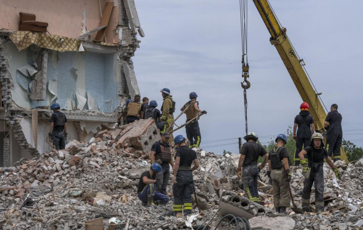 Rescue workers sift through rubble at the scene in the after math of a Russian rocket that hit an apartment residential block, in Chasiv Yar, Donetsk region, eastern Ukraine, Sunday, July 10,