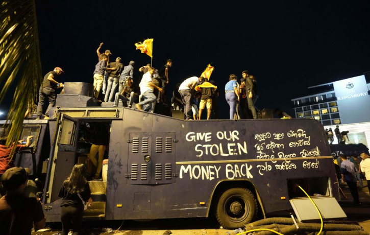 Protesters stand on a vandalised police water canon truck and shout slogans at the entrance to president's official residence in Colombo, Sri Lanka, Saturday, July 9, 2022.  AP/RSS Photo