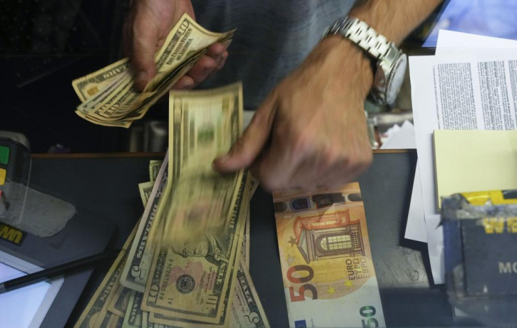 FILE - A cashier changes a 50 Euro banknote with US dollars at an exchange counter in Rome, Wednesday, July 13, 2022.  AP/RSS Photo