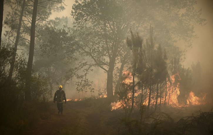 A firefighter walks among flames at a forest fire near Louchats, 35 kms (22 miles) from Landiras in Gironde, southwestern France, Monday, July 18, 2022. AP/RSS Photo