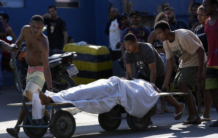 Residents use a cart to transport a body after a police operation that resulted in multiple deaths, in the Complexo do Alemao favela in Rio de Janeiro, Brazil, Thursday, July 21, 2022.  AP/RS