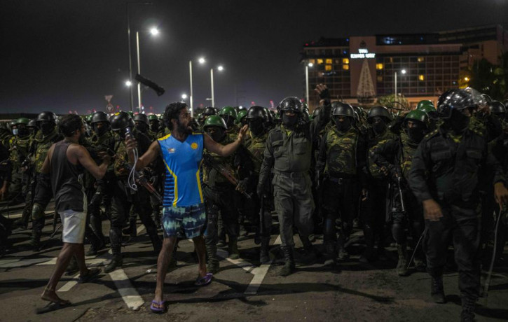 A protester shouts slogans as army soldiers arrive to remove protesters from the site of a protest camp outside the Presidential Secretariat in Colombo, Sri Lanka, Friday, July 22, 2022. (AP 