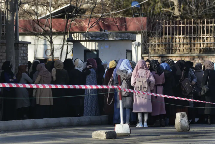 FILE - Afghan students queue at one of Kabul University's gates in Kabul, Afghanistan, on Feb. 26, 2022.  AP/RSS Photo
