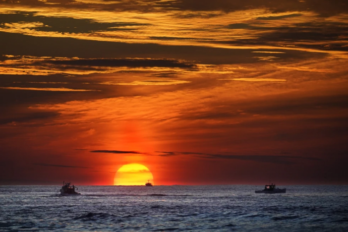 FILE - The sun rises over fishing boats in the Atlantic Ocean, Sept. 8, 2022, off of Kennebunkport, Maine.  AP/RSS Photo