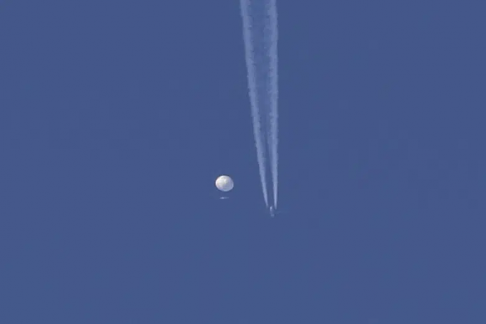 In this photo provided by Brian Branch, a large balloon drifts above the Kingstown, N.C. area, with an airplane and its contrail seen below it. AP/RSS Photo