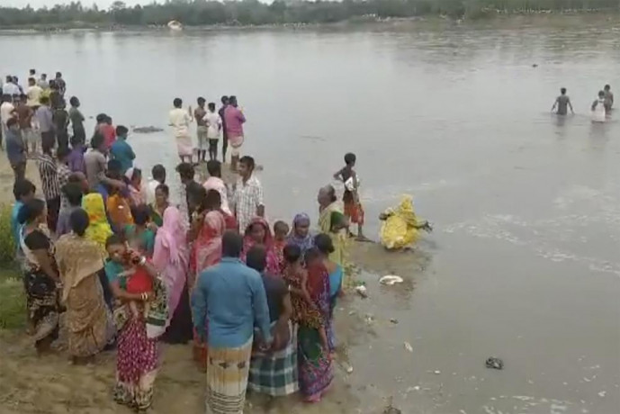 In this image made from a video, people conduct search operation in the River Karatoa where an overcrowded boat overturned, in Panchagarh, Bangladesh Sunday, Sept. 25, 2022.  AP/RSS Photo