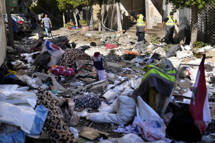 Hezbollah paramedics walk between debris after an airstrike hit an apartment in a multistory building, in central Beirut, Lebanon, Thursday, Oct. 3, 2024. (AP Photo)