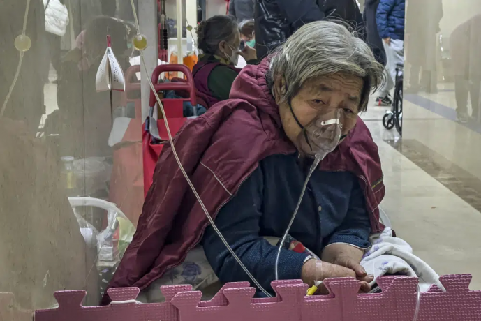 An elderly patient receives an intravenous drip while using a ventilator in the hallway of the emergency ward in Beijing, Thursday, Jan. 5, 2023. AP/RSS Photo