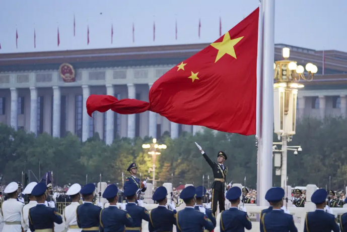 FILE - In this photo released by Xinhua News Agency, a member of the Chinese honor guard unfurls the Chinese national flag during a flag raising ceremony to mark the 73rd anniversary of the founding of the People's Republic of China held at the Tiananmen Square in Beijing on Oct. 1, 2022.  AP/RSS Photo