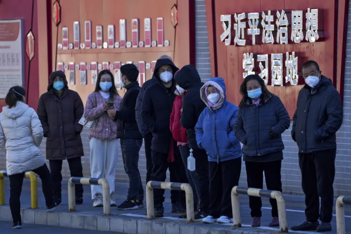 Residents wearing face masks line up for their routine COVID-19 tests along a wall displaying the words "Xi Jinping rule of law ideology learning ground" in Beijing, Monday, Dec. 5, 2022. AP/RSS Photo