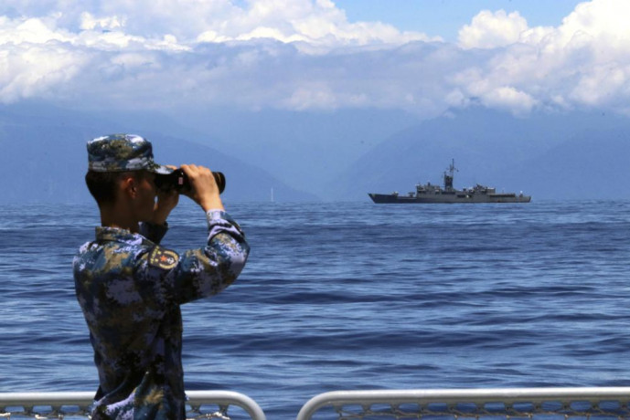 FILE - In this photo provided by China's Xinhua News Agency, a People's Liberation Army member looks through binoculars during military exercises as Taiwan's frigate Lan Yang is seen at the rear on Aug. 5, 2022. AP/RSS Photo