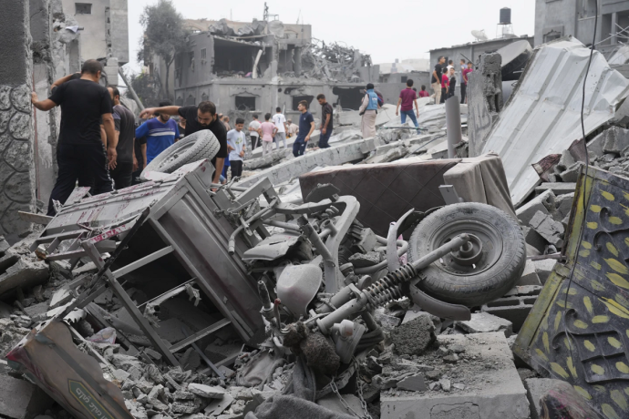 Palestinians walk about buildings destroyed in the Israeli bombardment in the Nusseirat refugee camp in the Gaza Strip on Sunday, Oct. 29, 2023. AP/RSS Photo