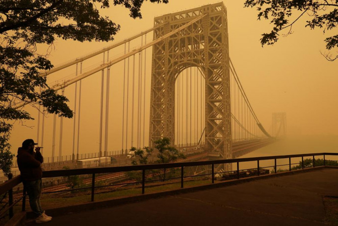 A man talks on his phone as he looks through the haze at the George Washington Bridge in Fort Lee, New Jersey, Wednesday, June 7, 2023. AP/RSS Photo