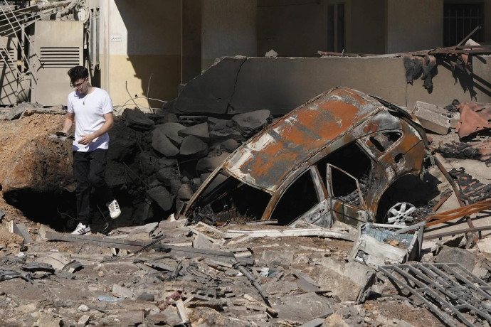 A man walks on rubble at the site of an Israeli airstrike in Beirut's southern suburbs, Sunday, Sept. 29, 2024. (AP Photo)