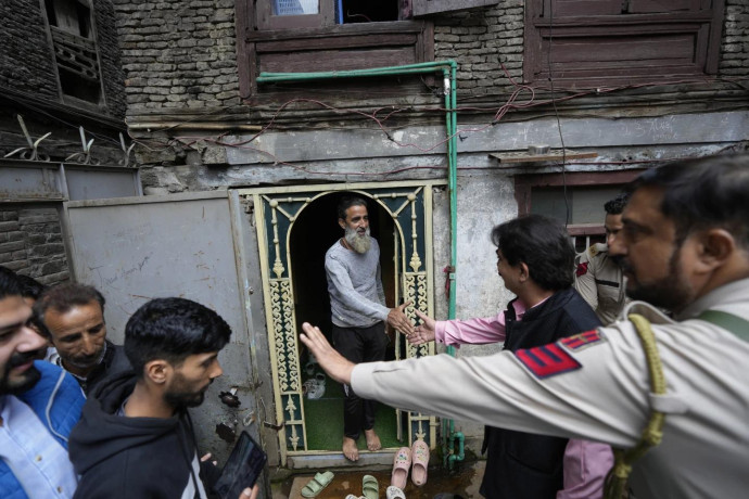 Ashok Bhat, right, a candidate of the Bharatiya Janata Party (BJP) talks to an elderly Kashmiri woman, while campaigning door-to-door ahead of the Jammu and Kashmir state assembly elections, in Srinagar, Indian controlled Kashmir, Thursday, Aug. 29, 2024. (AP Photo)