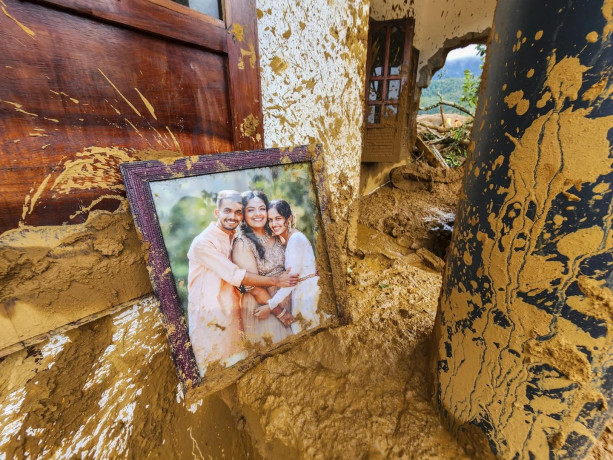 A framed photograph lies partially covered in mud at a damaged house after landslides hit hilly villages in Wayanad district, Kerala state, India, Tuesday, July 30, 2024. (AP Photo)