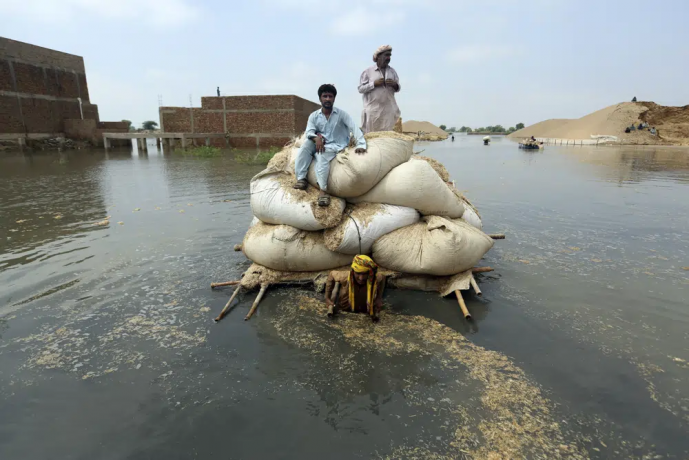 Flood victims from monsoon rain use a makeshift barge to carry hay for cattle, in Jaffarabad, a district of Pakistan's southwestern Baluchistan province, on Sept. 5, 2022.  AP/RSS Photo