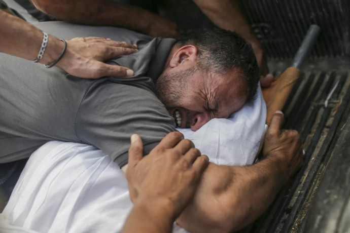 Palestinians mourn over the bodies of relatives killed in an Israeli airstrike, at a morgue in Al-Aqsa Martyrs Hospital in Deir al Balah, the Gaza Strip, Monday, June 10, 2024. (AP Photo)