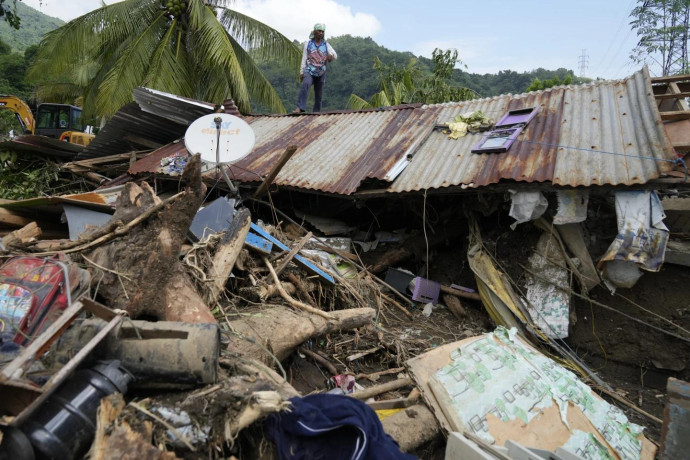 Marcelino Aringo speaks near his damaged house after a landslide triggered by Tropical Storm Trami struck homes, leaving several villagers dead in Talisay, Batangas province, Philippines on Saturday, Oct. 26, 2024. (AP Photo)