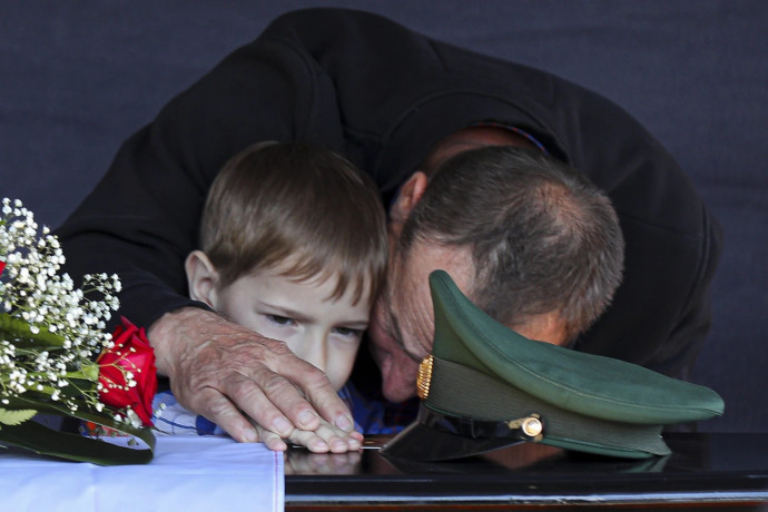 FILE - The father and son of Russian army Sgt. Daniil Dumenko, 35, who was killed in Ukraine, mourn his death at a ceremony in Volzhsky, outside Volgograd, Russia, on May 26, 2022. (AP/RSS Photo)