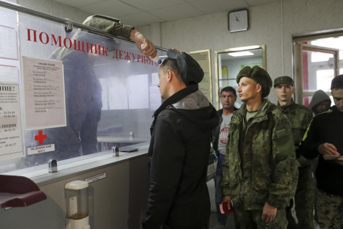 A Russian officer checks the temperature of recruits as they lineup to be registered at a military recruitment center in Volgograd, Russia, Saturday, Sept. 24, 2022. AP/RSS Photo