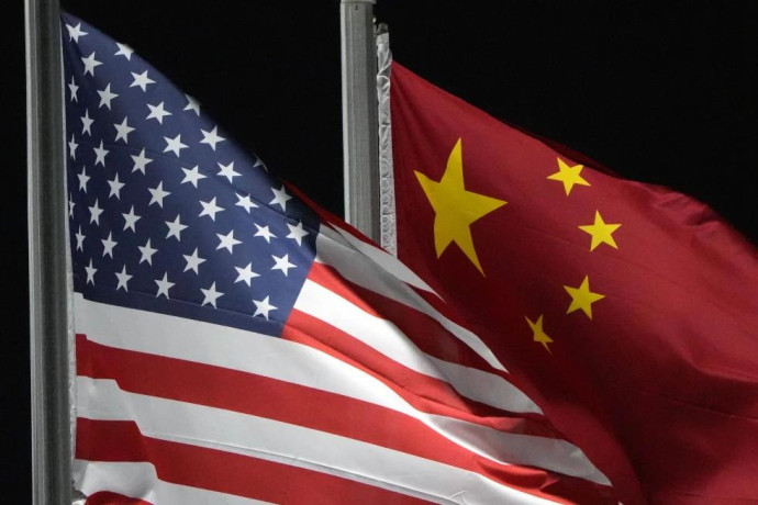 FILE - The American and Chinese flags wave at Genting Snow Park ahead of the 2022 Winter Olympics, Feb. 2, 2022, in Zhangjiakou, China. (AP Photo)